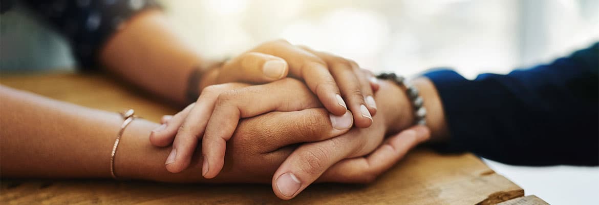 a close up photo of two people holding hands on a table