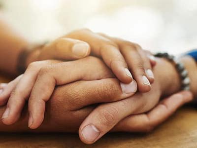 a close up photo of two people holding hands on a table