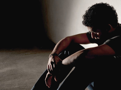 Man sitting on ground in shadows