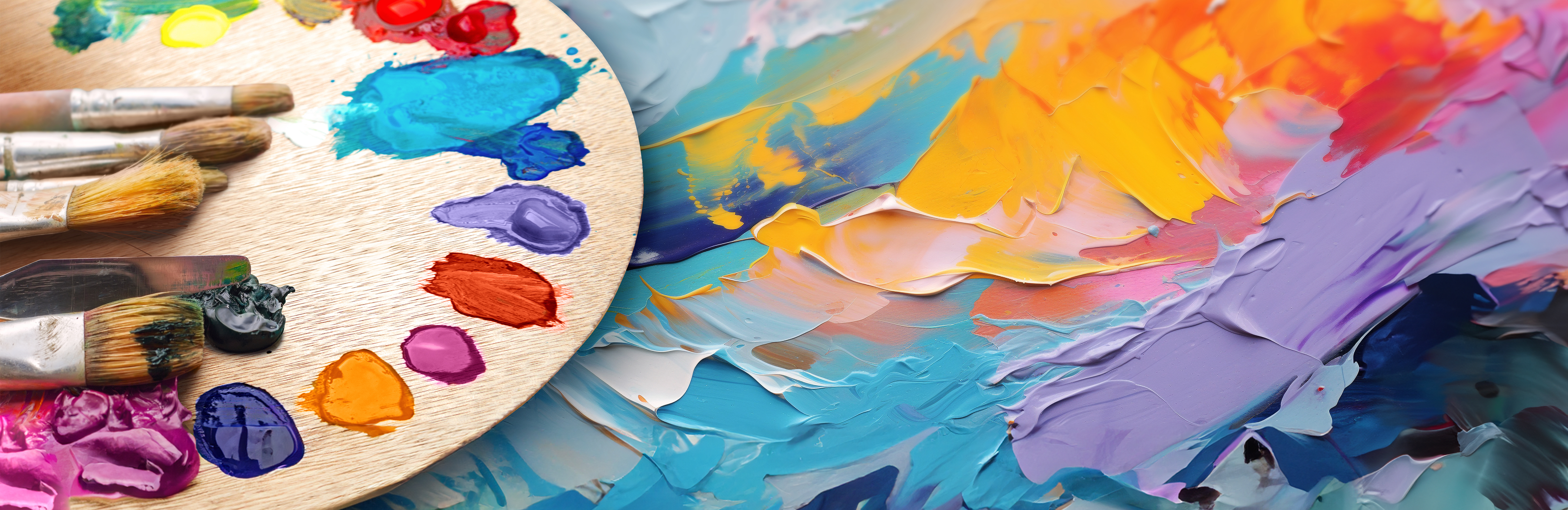 Brushes on a palette showing a variety of paint colours. The palette is over a canvas of an impressionistic painting of multi-coloured brush strokes.