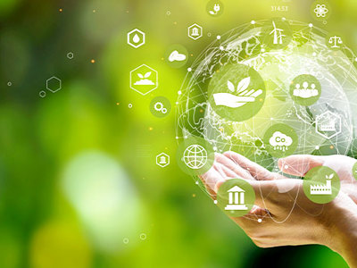 Photo of hands holding an illustrated sphere with various environmental symbols in it. 