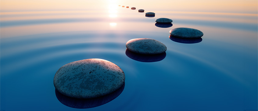 Stones in calm water with evening sun