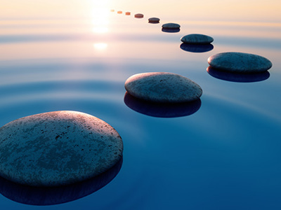 Stones in calm water with evening sun