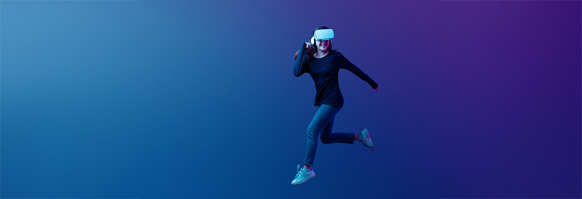 Girl in dark athletic wear running in an empty blue-coloured, virtual space and wearing a VR headset. 