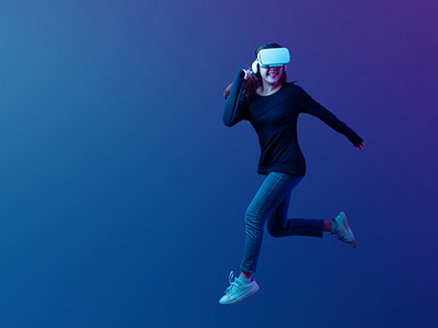 Girl in dark athletic wear running in an empty blue-coloured, virtual space and wearing a VR headset. 