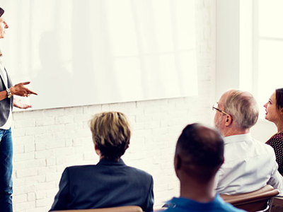 Woman giving presentation to group.