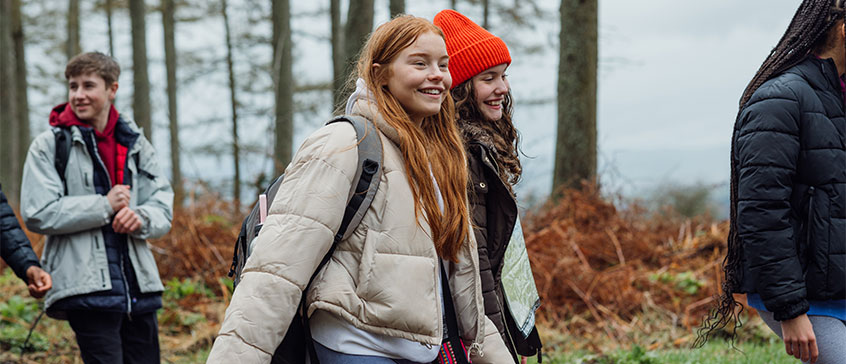 Two young girls walking in forest