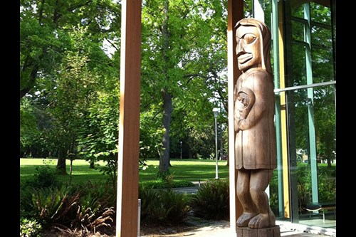 Photo of the carved pole outside of the first people's house on campus.