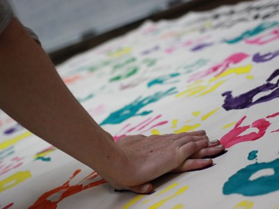 hands making a print on the mural