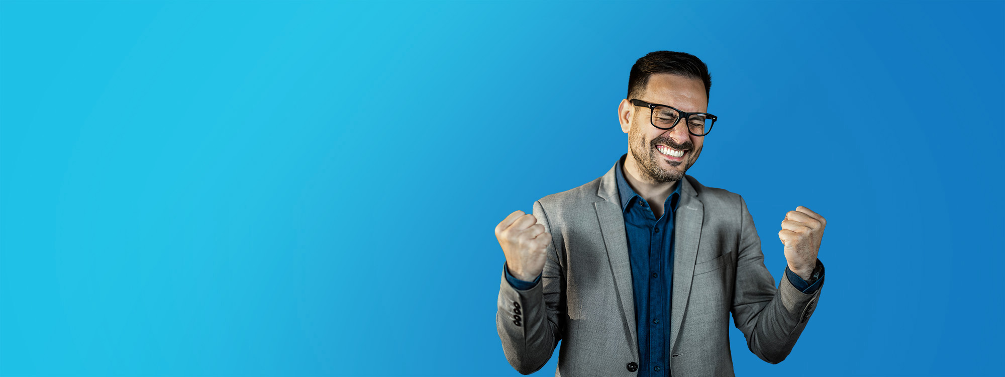 A smiling man in a blazer clenches his fists in celebration beside bold white and yellow text on a blue background that reads, “You don’t have to drive far to go far.”