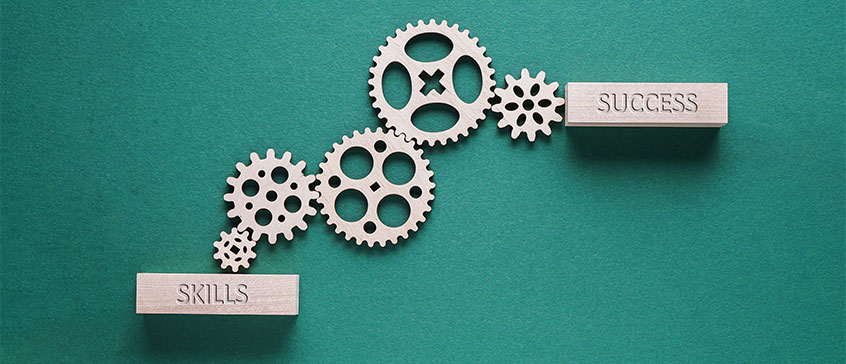 Illustration of cog wheels with the words skills and success. 