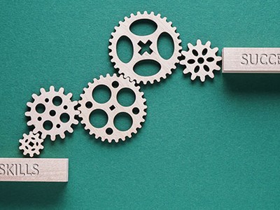 Illustration of cog wheels with the words skills and success. 