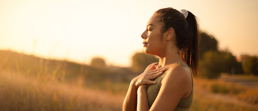 Photo of woman with eyes closed and hands on heart. 