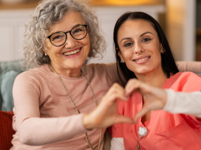 Nurse and senior putting hands together in the shape of a heart