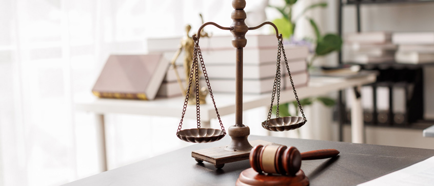 Illustration of a scale overtop silhouettes of abstract faces