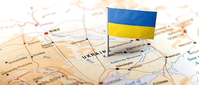 Photo of a miniature Ukrainian flag on top of a map of Ukraine. 