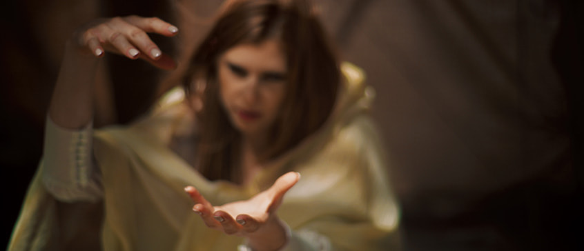 Mysterious, redhead woman throwing a spell during meditation. Shade and light beams