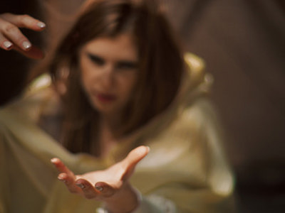 Mysterious, redhead woman throwing a spell during meditation. Shade and light beams