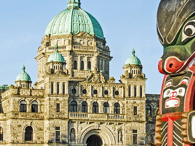 A totem pole in front of the Victoria, BC Parliament buildings