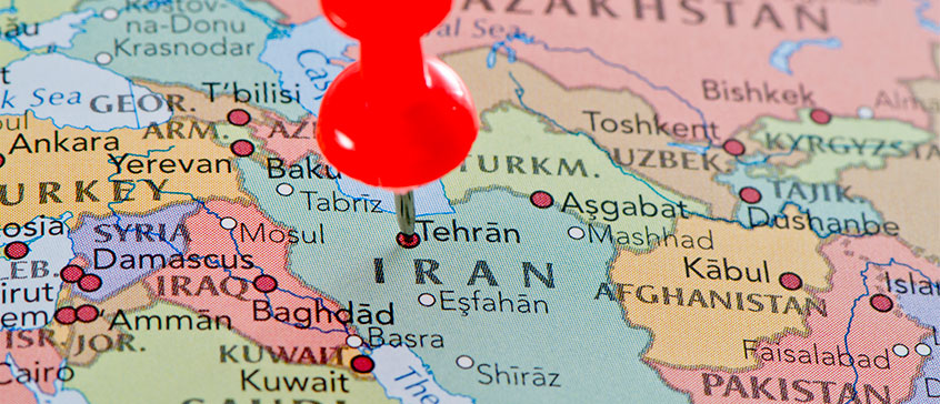 Photo of a world globe with a thumbtack on Iran.