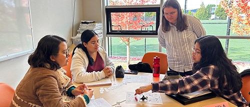 A teacher instructing students at a table