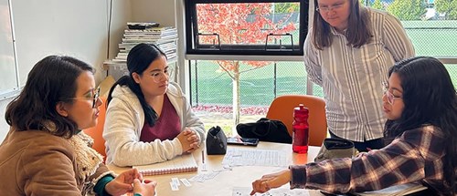 A teacher instructing students at a table