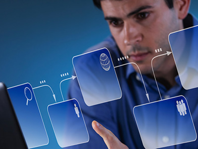 Person using a laptop with floating digital interface icons such as search, connectivity and user profiles, representing computing and information systems technology.