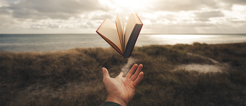 A picture of a levitating book above a hand. 
