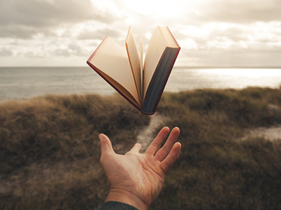 A picture of a levitating book above a hand. 