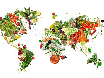 World map creatively formed from fresh vegetables, fruits, and herbs including tomatoes, leafy greens, carrots, and citrus, illustrating global food systems, sustainable agriculture, environmental connections, and plant-based nutrition across continents.