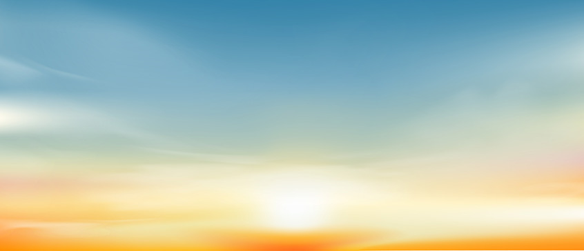 Sun rising through golden, yellow mist into a bright blue sky.