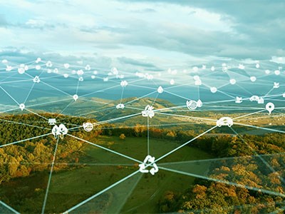 A scenic landscape of hills and forests with lines and icons showing the connection between technology and nature.