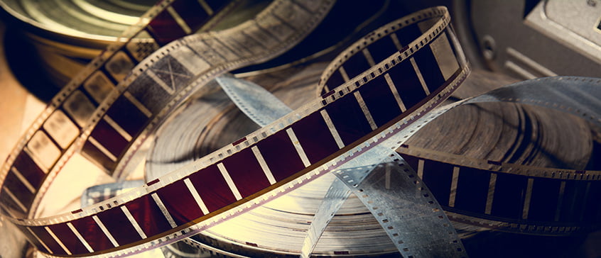 Close-up of vintage film reels and strips of 35mm film, symbolizing cinematic storytelling and the study of Latin American culture through contemporary movies.