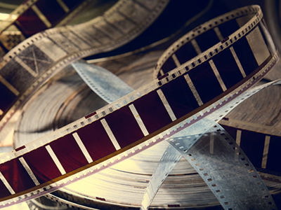 Close-up of vintage film reels and strips of 35mm film, symbolizing cinematic storytelling and the study of Latin American culture through contemporary movies.