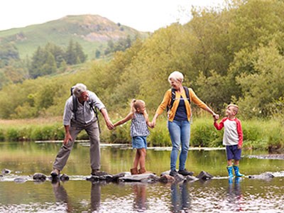 Older adults on an outdoor adventure with two young kids.