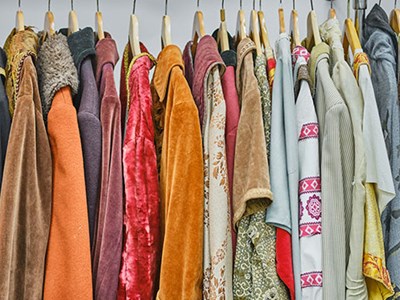 Photo of a clothing rack with garments of various colours and textures.