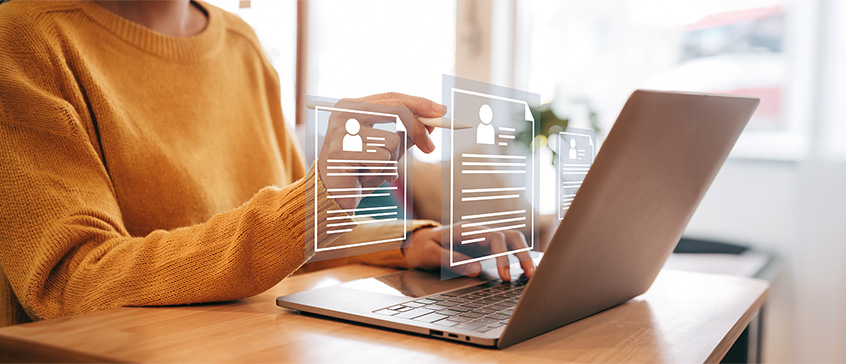 Professional reviewing online career profiles and résumé information on a laptop.