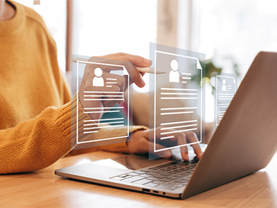 Professional reviewing online career profiles and résumé information on a laptop.