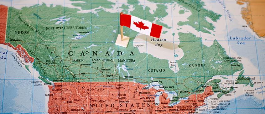 A map of North America focusing on Canada with a Canadian flag placed in the center of Canada.
