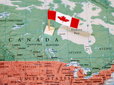 A map of North America focusing on Canada with a Canadian flag placed in the center of Canada.