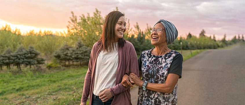 Young woman and old woman walking and smiling