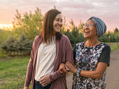 Young woman and old woman walking and smiling