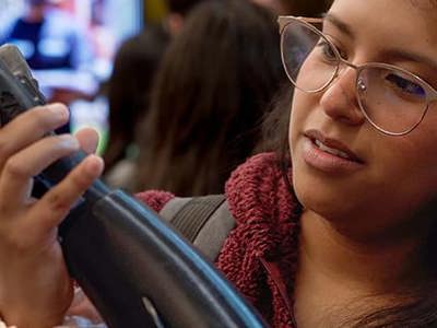 A student in a group English language class examining a prosthetic arm