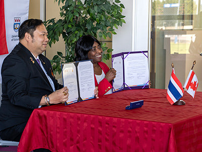Dr. Natworapol Rachsiriwatcharabul, President, Rajamangala University of Technology Phra Nakhon, Dr. Elizabeth Adjin-Tettey, Associate Vice-President Academic Programs, UVic holding up the signed Memorandum of Understanding between ELC, UVic and RMTUP