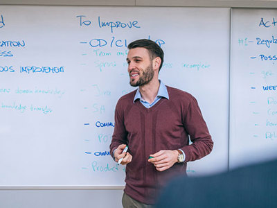 Image of facilitator in front of whiteboard.