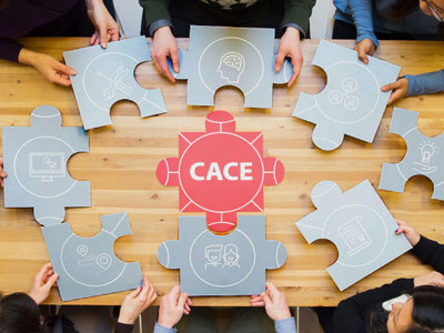 Students sitting at table holding puzzle pieces. 