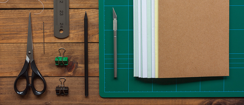 Photo of artist book and supplies laid out on table.  