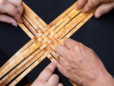 Photo of hands weaving cedar bark.