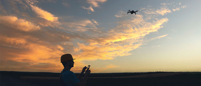 Silhouette of drone operator against sunset. 