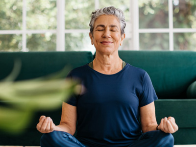 Woman meditating in lotus position at home